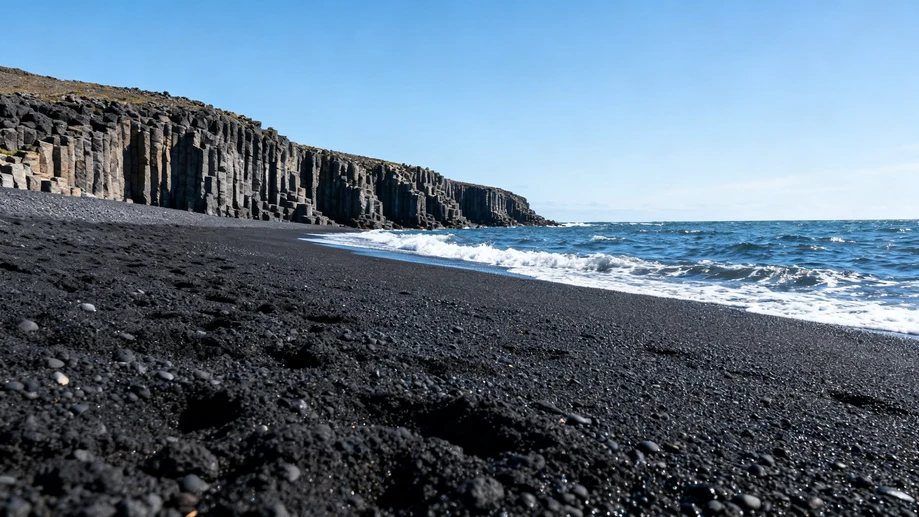 Wandering along dramatic jet-black volcanic shores of Iceland’s iconic Reynisfjara Black Beach in bright summer light